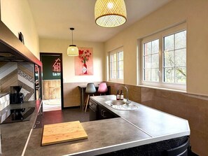 A modern kitchen with a large island, a coffee machine, and a dining area with chairs. - The Saint-Josse Tribe (Saint-Josse)