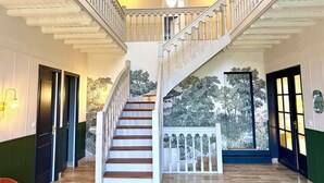 A grand staircase with white balustrades, a wooden floor, and a mural of trees on the wall. - The Saint-Josse Tribe (Saint-Josse)