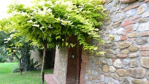 Un bâtiment en pierre avec une entrée en briques et un chemin qui y mène.