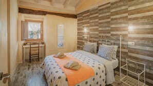 Een slaapkamer met een bed, een bureau en een raam.