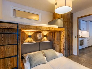 Une chambre à coucher avec une tête de lit en bois, un lit avec des oreillers, une table de chevet et un luminaire suspendu.