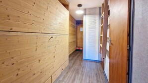 Ein Korridor mit Holzwandverkleidung und einer Holztür auf der rechten Seite.