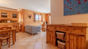 Un interior rústico de madera con comedor, sofá y cocina.