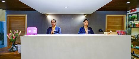 Un mostrador de recepción con dos empleados.