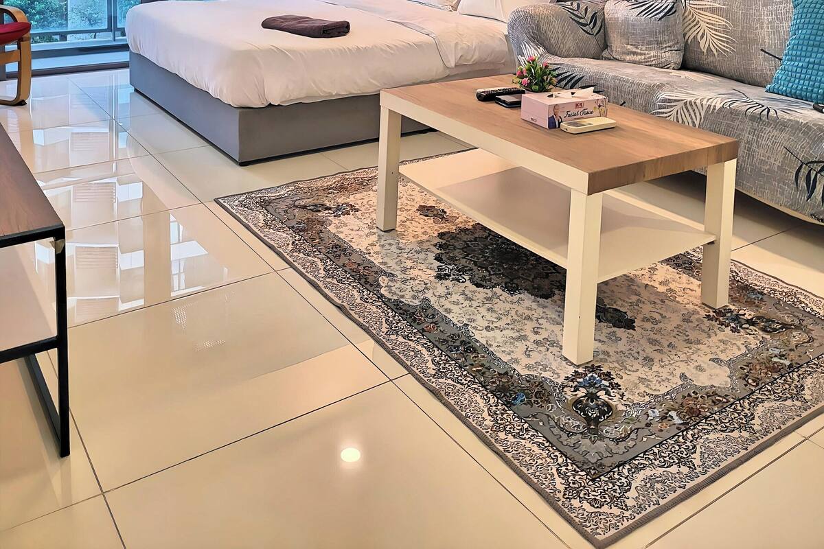 Une chambre d’hôtel moderne avec un grand lit, un canapé, une table basse et des œuvres d’art accrochées aux murs.