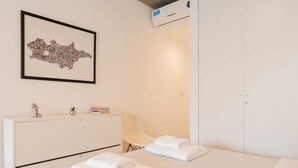 A hotel room with a bed, a bedside table with a lamp, a framed artwork on the wall, and a wardrobe. - MOT Rentals + Ravignani 2100 - Lux Loft Terrace & Jacuzzi (Buenos Aires)