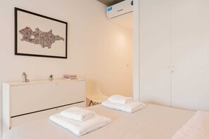 A hotel room with a bed, a bedside table with a lamp, a framed artwork on the wall, and a wardrobe. - MOT Rentals + Ravignani 2100 - Lux Loft Terrace & Jacuzzi (Buenos Aires)