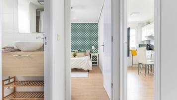 Een moderne slaapkamer met een groot bed, een nachtkastje en een muur met een groen patroon.