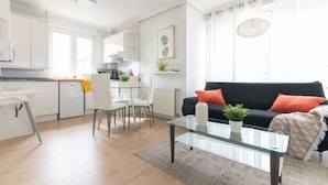 En moderne lejlighed med køkken, spiseområde og opholdsstue.