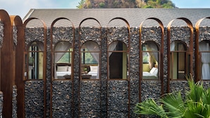 A stone building with arched windows and a view of a mountain. - AiLee Villa & Hotel Tamcoc (Nam Hoa Lu)