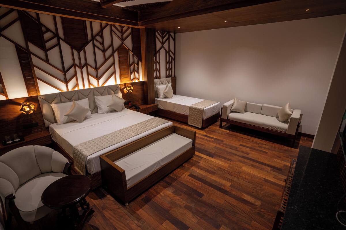 A modern bedroom with a large bed, two smaller beds, a sofa, and a chair.