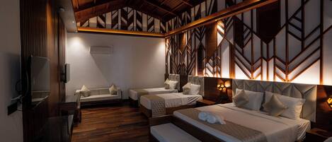 A hotel room with a wooden ceiling, two beds, a sofa, and a TV.