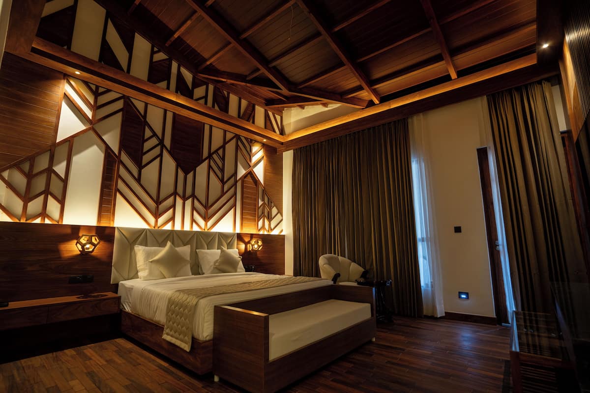 A modern bedroom with a large bed, wooden headboard, and built-in lighting.