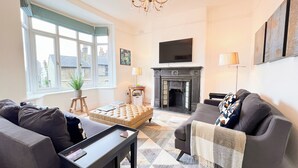 Ein Wohnzimmer mit Kamin, zwei Sofas, einem Couchtisch und einem Fernseher.