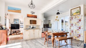 Una cocina amplia con armarios de madera, una mesa de comedor y un televisor.