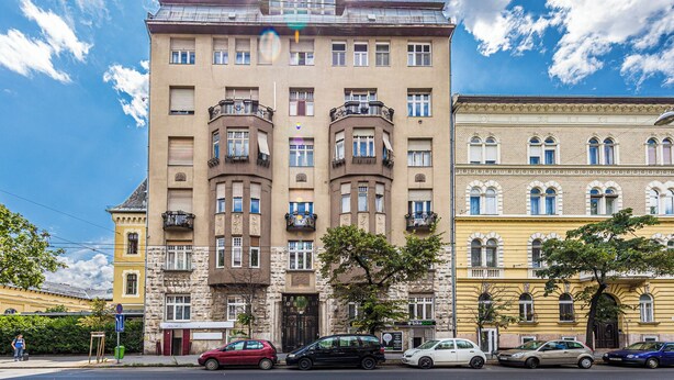 Un immeuble à plusieurs étages doté d’une cour intérieure, de balcons et présentant un mélange de styles architecturaux.