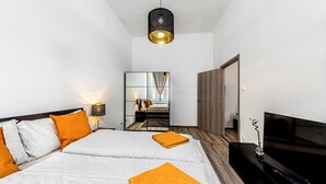 Une chambre d’hôtel moderne avec un grand lit, une télévision et un miroir.