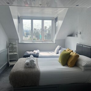 Habitación triple, vista parcial al mar | Escritorio, tabla de planchar con plancha y wifi gratis 