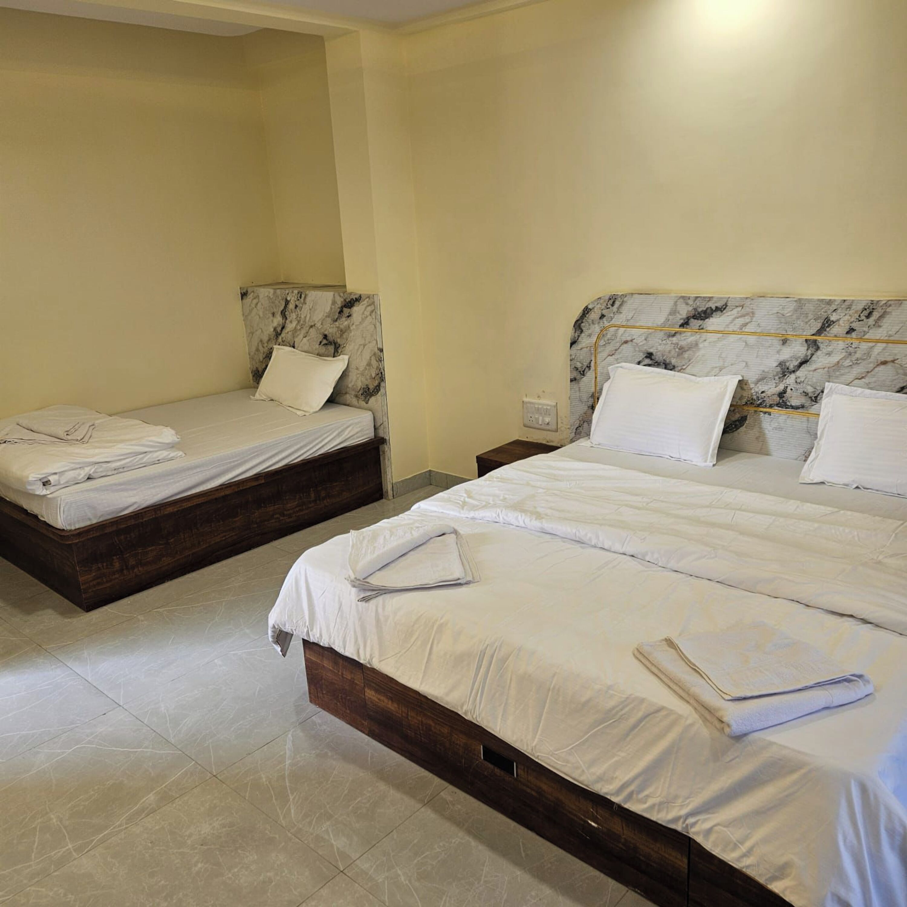 Two twin beds with marble headboards in a hotel room.