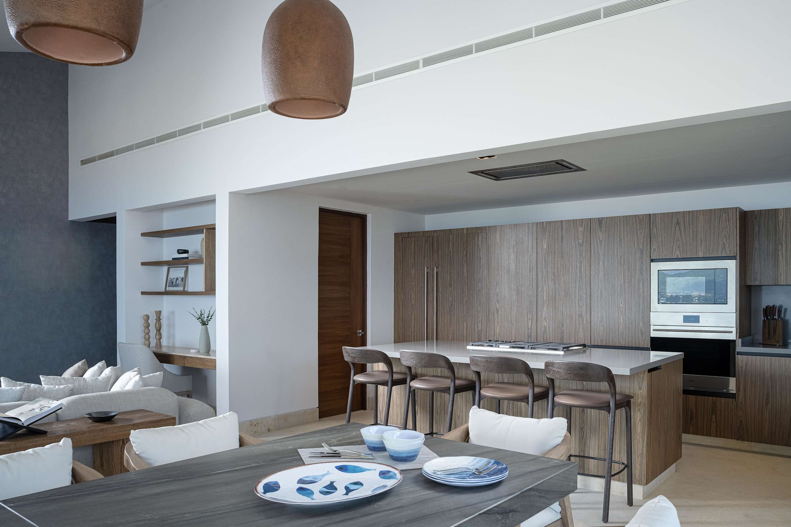 Een moderne keuken met een centraal eiland, houten kastjes en een ingebouwde oven.