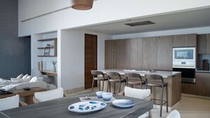 A modern kitchen with a central island, wooden cabinets, and a built-in oven. - Casa Ravello: Luxury Villa, Full Service & Premier Golf (Punta Mita)