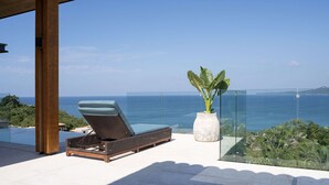 A sun lounger with a view of the sea, a large potted plant, and a glass balustrade. - Casa Ravello: Luxury Villa, Full Service & Premier Golf (Punta Mita)