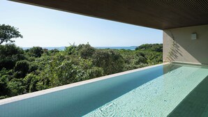 Una piscina con vistas a un bosque y un paisaje lejano.