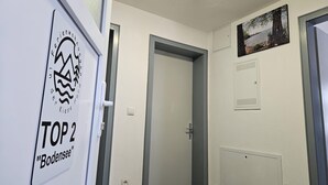 A hallway with a door labeled "Top 2 Bodensee" and a framed picture on the wall. - FeWo in der Kiese Hard - Top 2 "Bodensee" with a large terrace (Hard)