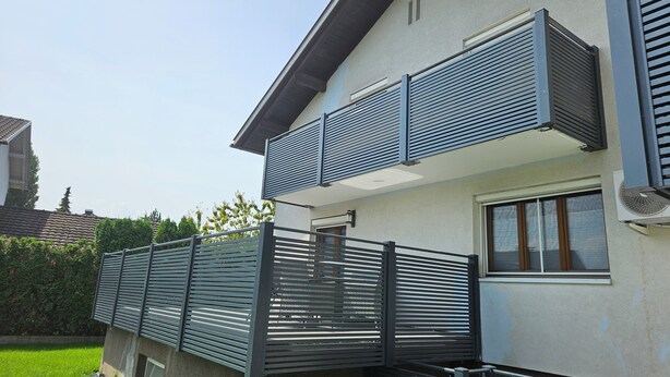 A modern two-story residential building with a balcony and a security gate. - FeWo in der Kiese Hard - Top 2 "Bodensee" with a large terrace (Hard)