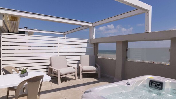 A rooftop terrace with a hot tub, seating area, and a view of the sea. - Residence Flow-r (Riccione)