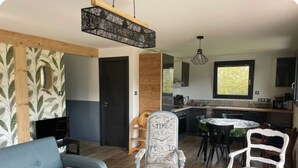 A modern living room with a sofa, chairs, and a dining area with a table and chairs. - Charming chalet in Gérardmer To relax with family and friends  (Gérardmer)