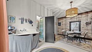 Un baño moderno con un lavamanos blanco, una alfombrilla de baño a rayas y un perchero para toallas.