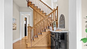 A wooden staircase with a black cabinet at the bottom. - Classic & elegant Victorian home in Old Louisville (Louisville)