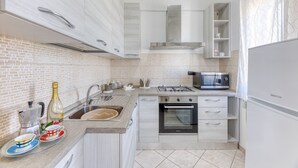 A modern kitchen with a gas stove, oven, microwave, and a built-in sink. - Apartment 'Mirea' with Private Terrace, Wi-Fi and Air Conditioning (Melissano)