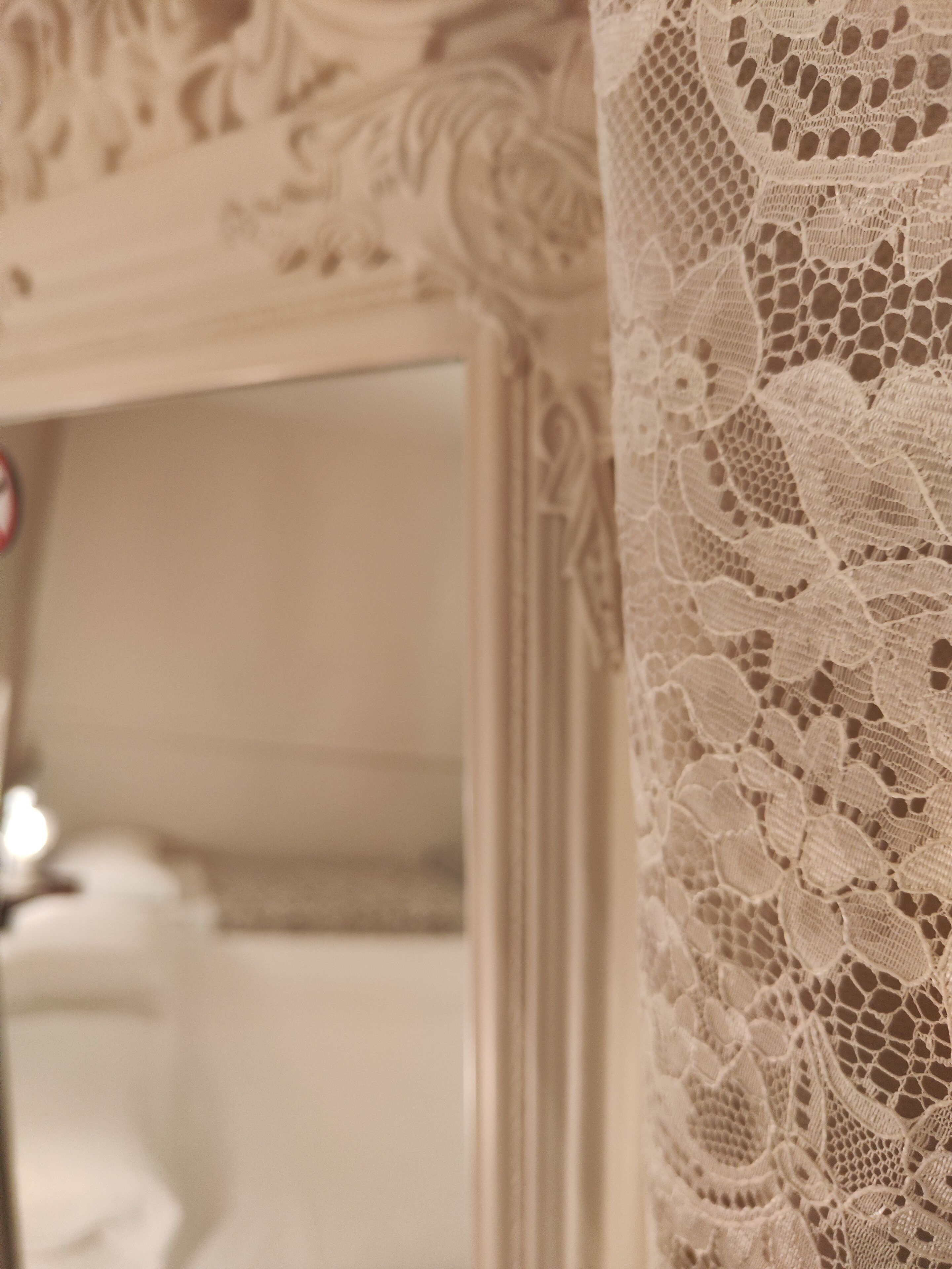 Un gros plan d’un rideau blanc en dentelle orné d’un motif floral.