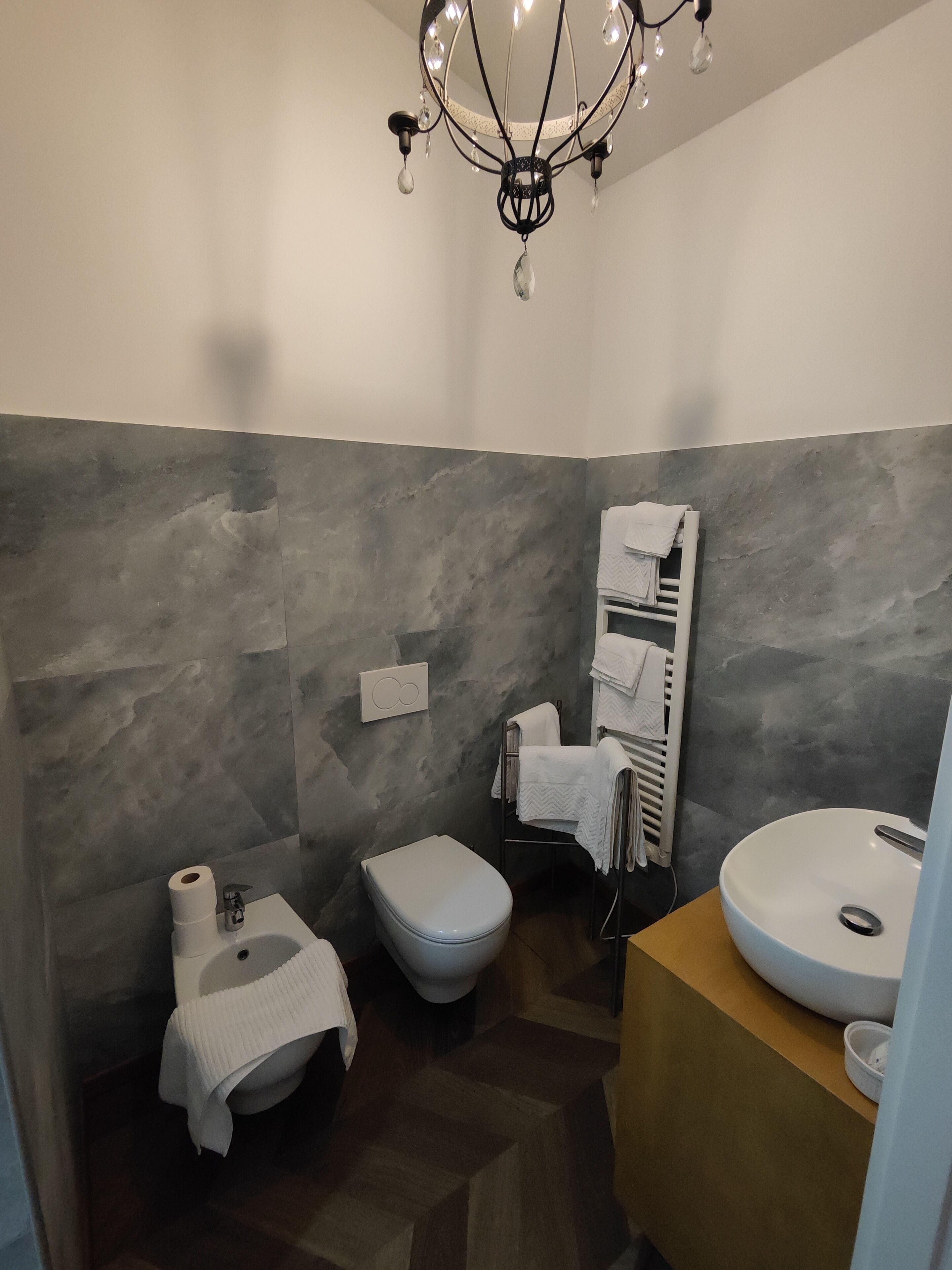 Een moderne badkamer met een wit toilet, een witte wastafel en een douchehoek.