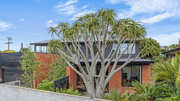 Une maison moderne avec un grand arbre dans le jardin.