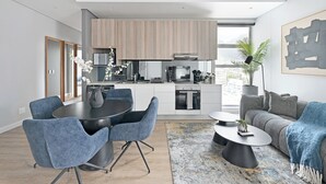 A modern apartment with a dining area, kitchen, and living space. - 2-Bed City Escape with Mountain Views (Cape Town)
