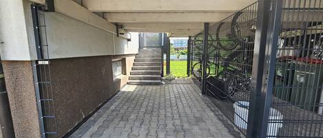A covered outdoor area with a paved walkway leading to a staircase.
