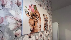 A bathroom with a floral wallpaper, a mirror, and a wooden stool.
