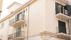 A building with a beige facade, multiple balconies, and a door labeled "MY OFFICE".