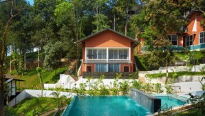 A two-story house with a swimming pool, surrounded by lush greenery and trees. - ERA Resort by Stride (Devikolam)
