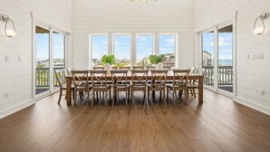 Un comedor amplio con techo alto, ventanas grandes y vista al océano.
