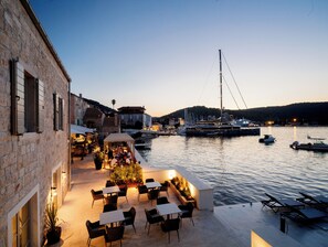 A waterfront restaurant with outdoor seating overlooking a marina. - MARSHAL CLUB HOTEL (Vis)