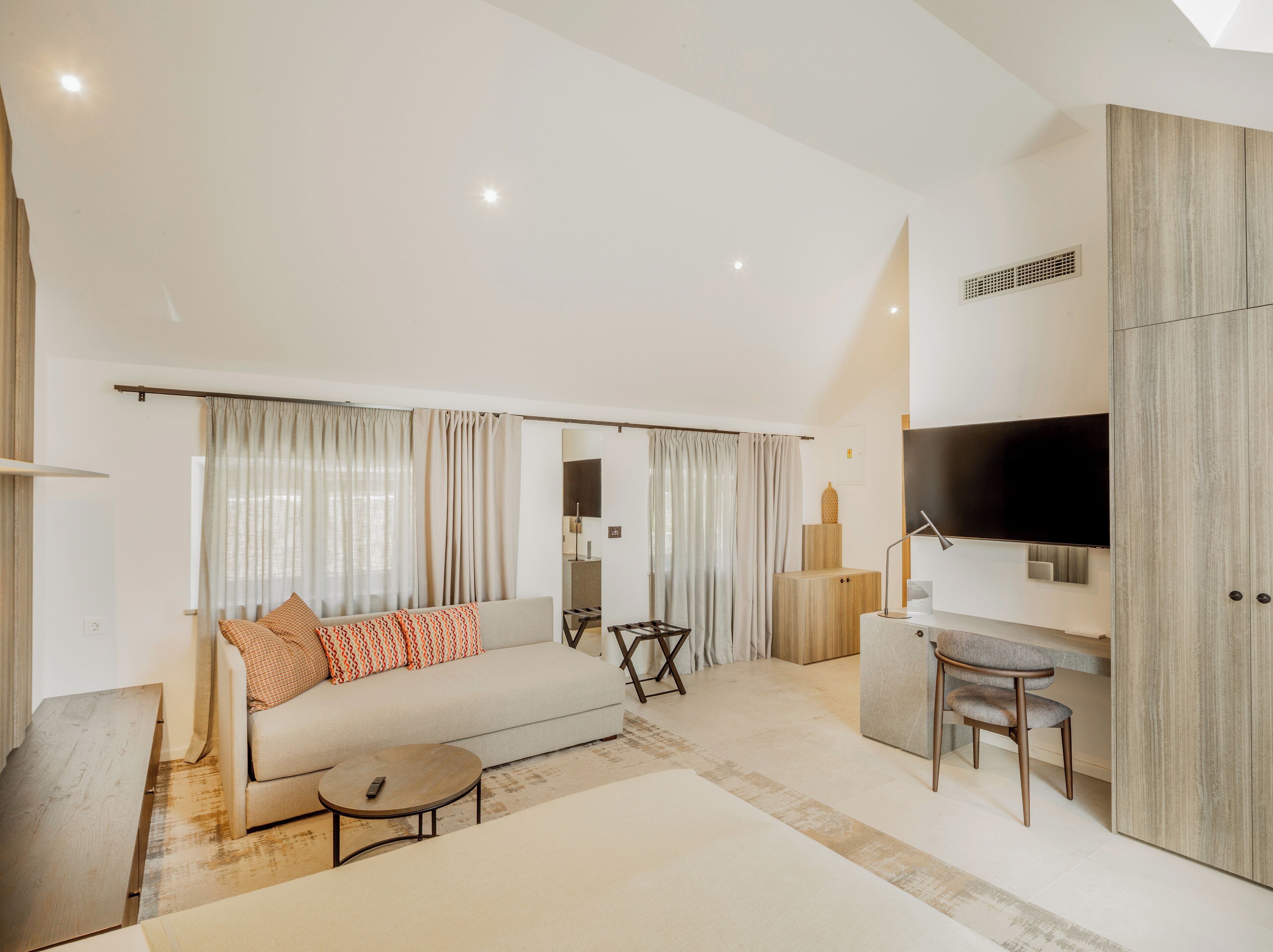 A modern living room with a sofa, coffee table, and TV area.
