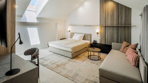 Une chambre moderne comprenant un lit, un bureau, une chaise, un canapé et une petite table.