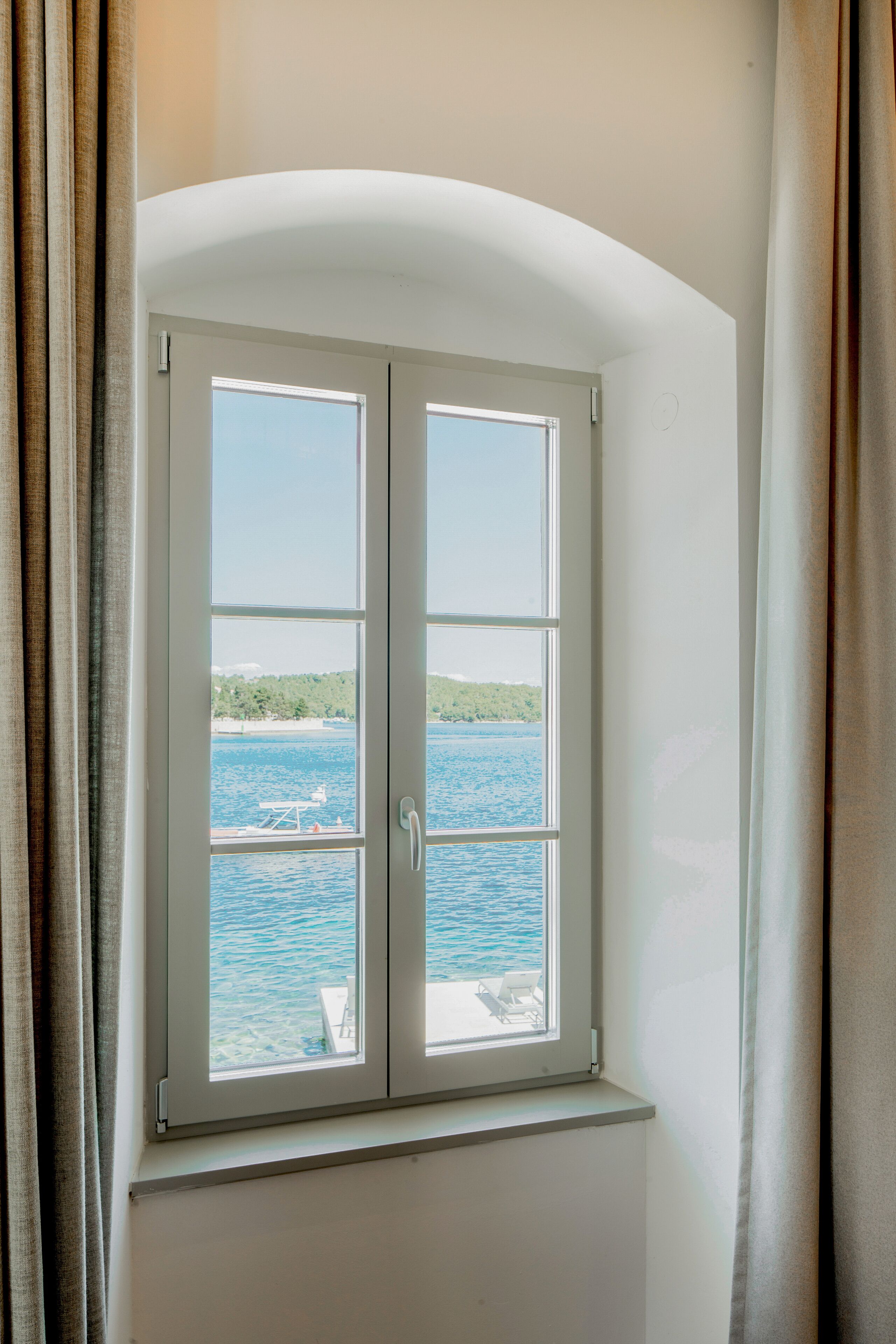 Una ventana con vista a un cuerpo de agua y un barco.