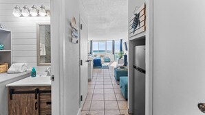 Un pasillo estrecho que conduce a una sala de estar con vista al mar.