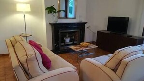 A living room with a sofa, a coffee table with snacks, a fireplace, a TV, and a lamp. - LITTLE HOUSE & GARDEN IN PALMA NEXT TO UNIVERSITY (Palma)