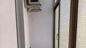 A narrow bathroom with a window, a small sink, and a mop leaning against the wall. - Cool apartment with AC in Piombino (Piombino)